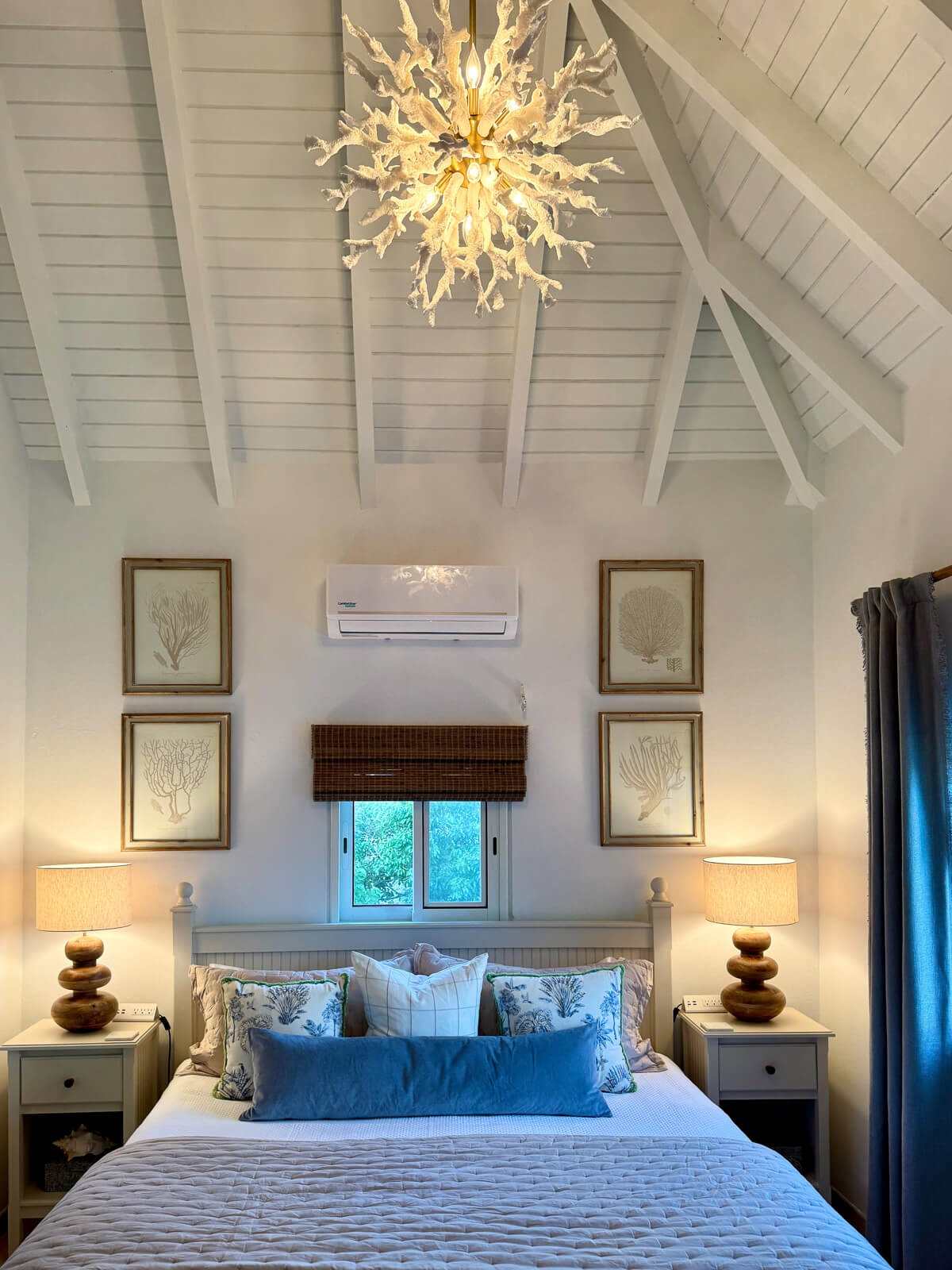 Reef Retreat bedroom — vaulted ceilings, layered king bed, soft coastal tones